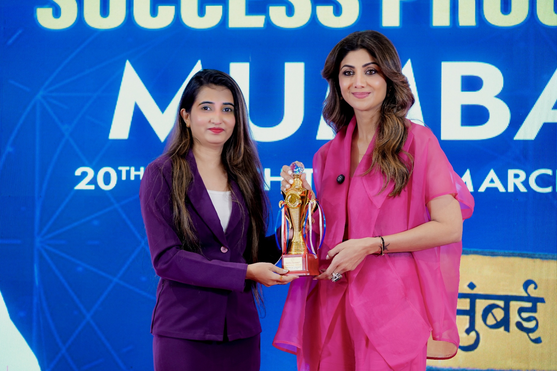 Darshanii receiving a recognition on stage
